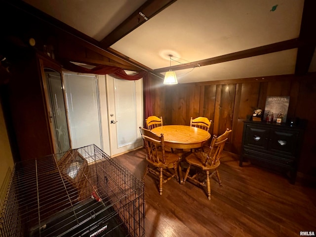 dining area featuring wood walls and dark hardwood / wood-style flooring