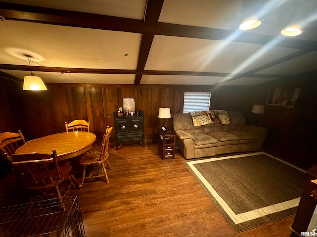 living room with beamed ceiling, wood-type flooring, and wooden walls