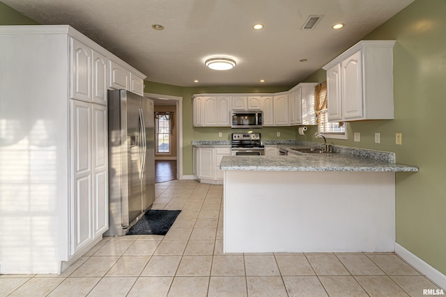 kitchen featuring white cabinetry, appliances with stainless steel finishes, sink, and kitchen peninsula