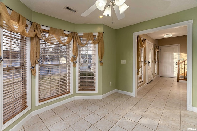 empty room featuring ceiling fan and light tile patterned flooring