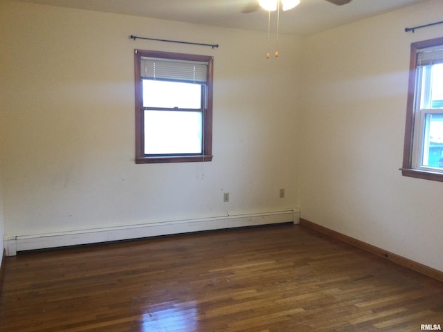 empty room featuring baseboard heating, dark wood-type flooring, and ceiling fan