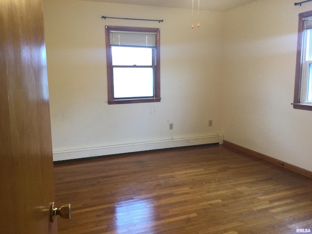 spare room featuring a baseboard radiator and dark hardwood / wood-style flooring