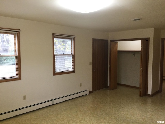 unfurnished bedroom featuring a baseboard radiator and a closet