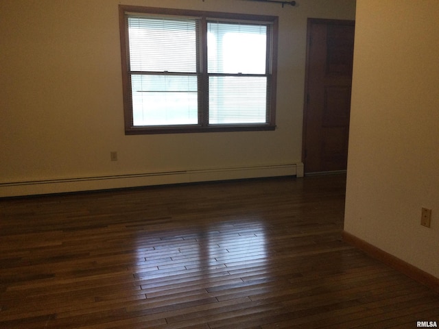 unfurnished room with dark wood-type flooring and a baseboard radiator