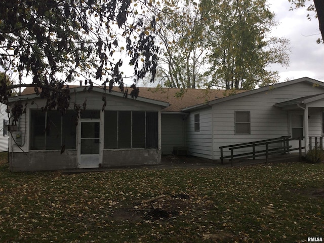 rear view of house featuring a sunroom