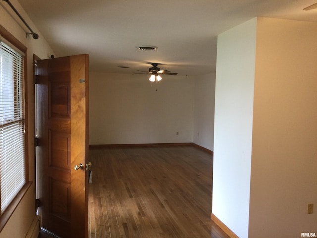 spare room featuring dark wood-type flooring and ceiling fan