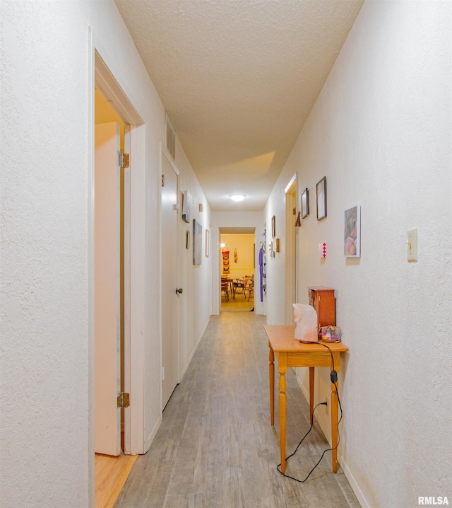 2857 State Route 161st Hwy, Centralia, IL 62801 - hall with light wood-style flooring, a textured wall, a textured ceiling, and baseboards
