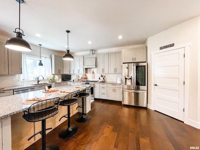 kitchen featuring a kitchen breakfast bar, custom range hood, dark hardwood / wood-style floors, appliances with stainless steel finishes, and decorative light fixtures