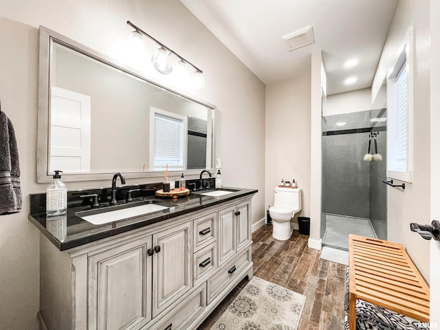 bathroom featuring a shower, wood-type flooring, vanity, and toilet