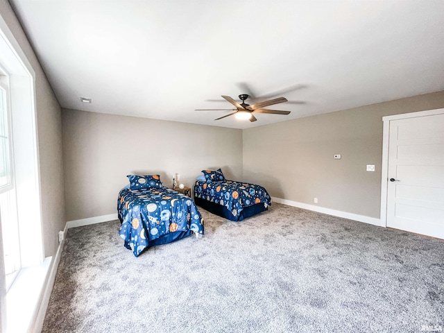 carpeted bedroom with multiple windows and ceiling fan