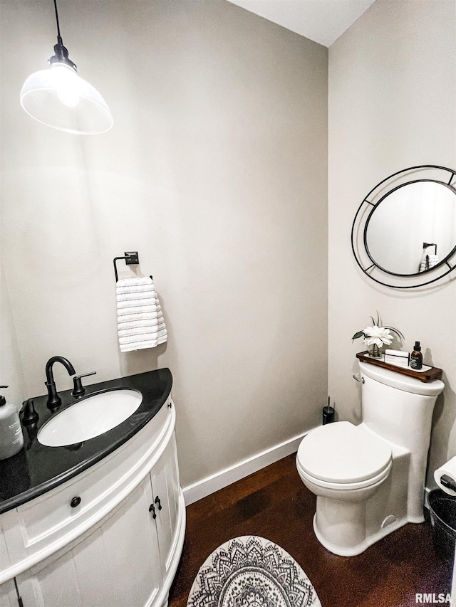 bathroom with toilet, vanity, and hardwood / wood-style flooring