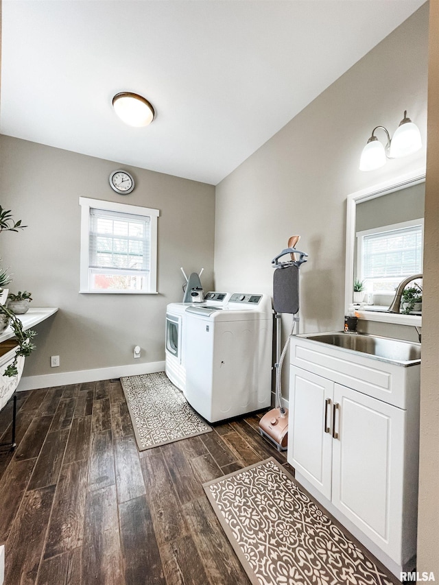 clothes washing area with a wealth of natural light, washer and dryer, sink, and dark hardwood / wood-style flooring