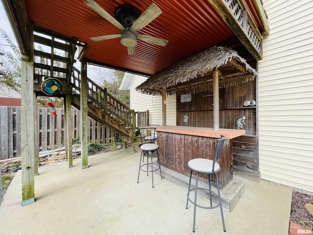 view of patio / terrace featuring ceiling fan and a bar