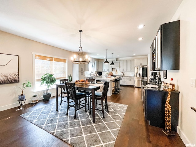 dining space featuring a notable chandelier, dark hardwood / wood-style floors, and sink