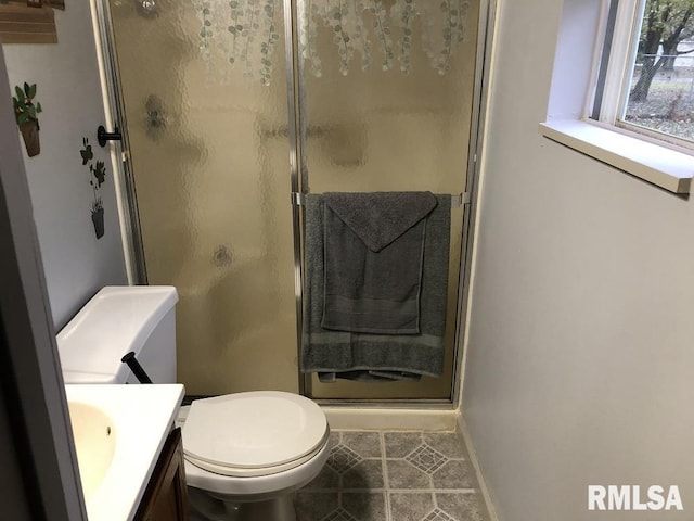 bathroom with tile patterned flooring, vanity, a shower with door, and toilet