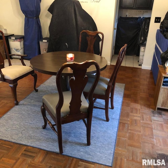 dining area with dark parquet flooring