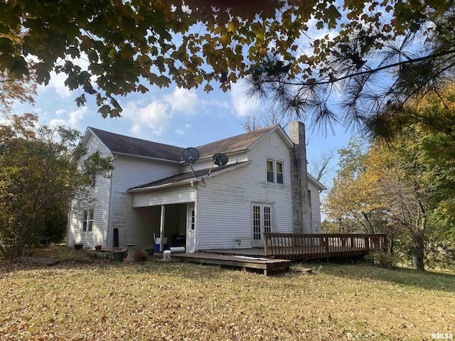 back of property featuring a lawn, a chimney, a wooden deck, and french doors