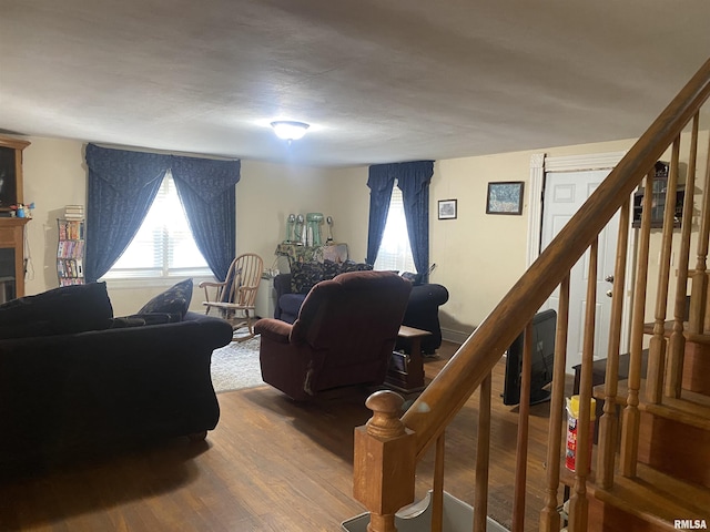 living area featuring stairway, plenty of natural light, and wood finished floors