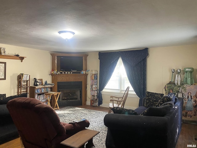 living room featuring a fireplace, visible vents, and wood finished floors