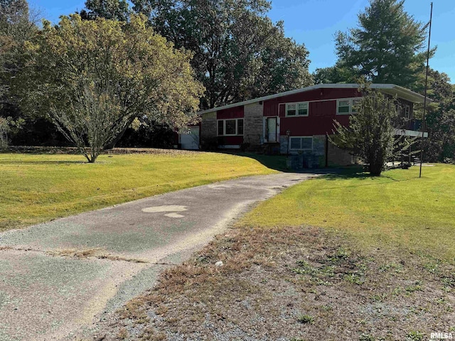 split foyer home featuring a front yard, stone siding, and driveway