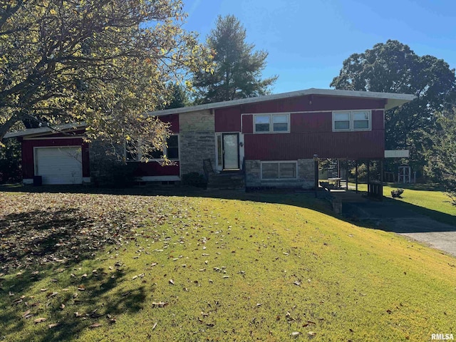 tri-level home with entry steps, a front lawn, an attached garage, and stone siding