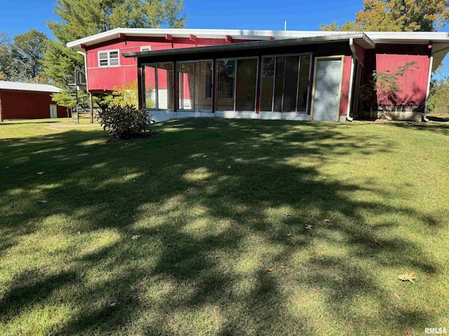 back of property with a sunroom and a yard