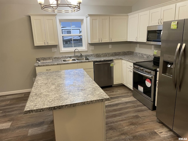 kitchen featuring dark wood-style floors, a kitchen island, appliances with stainless steel finishes, an inviting chandelier, and a sink