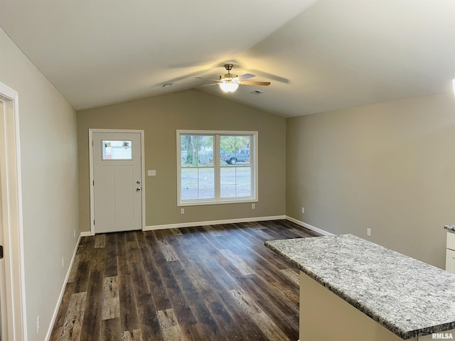 foyer entrance featuring vaulted ceiling, dark wood finished floors, a ceiling fan, and baseboards