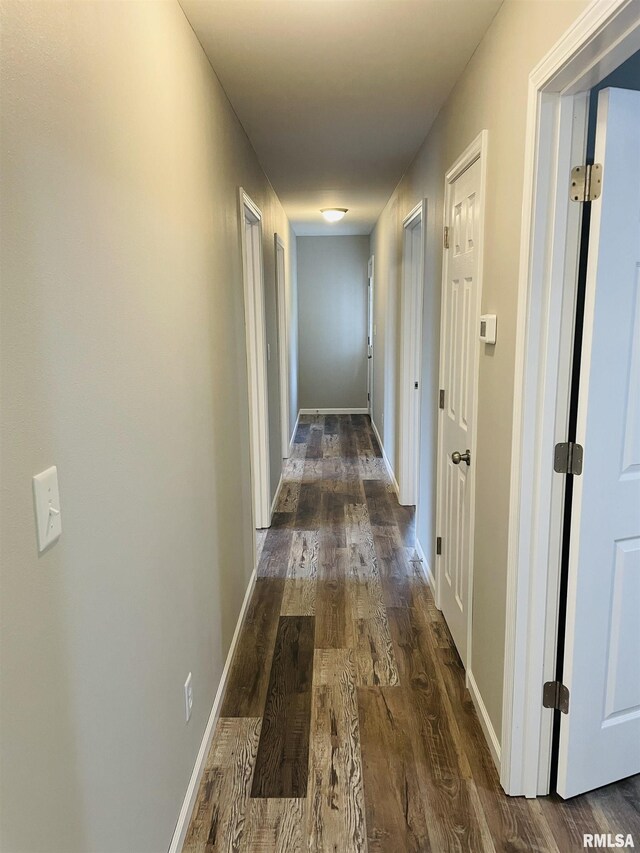 hall with baseboards and dark wood-style flooring