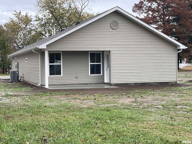 back of property with a lawn and central air condition unit