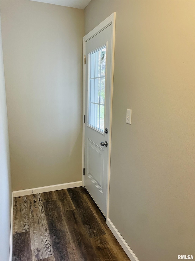 doorway featuring dark wood-style floors and baseboards