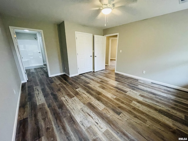 unfurnished bedroom with visible vents, dark wood finished floors, baseboards, and ensuite bathroom