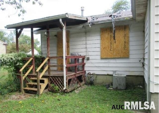 entrance to property featuring a wooden deck and cooling unit