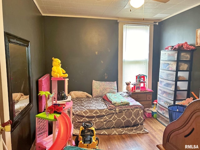 bedroom with hardwood / wood-style flooring, crown molding, and ceiling fan