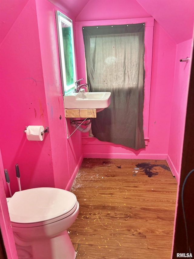 bathroom featuring toilet, sink, lofted ceiling, and wood-type flooring