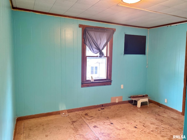 empty room with wood walls and crown molding