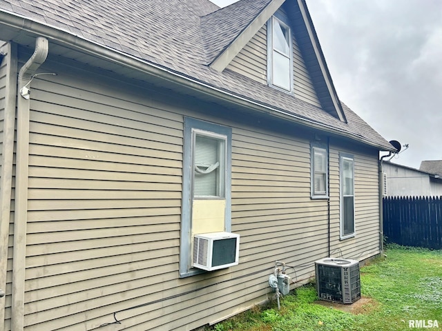 view of home's exterior with cooling unit, central AC, and a yard