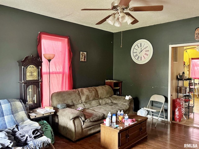 living room with a textured ceiling, dark hardwood / wood-style floors, and ceiling fan