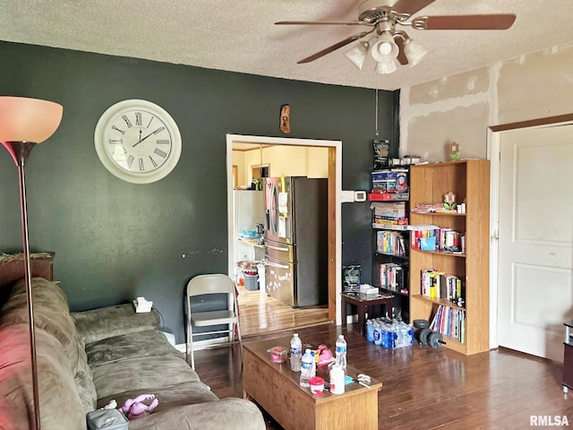 living room with ceiling fan, dark hardwood / wood-style floors, and a textured ceiling