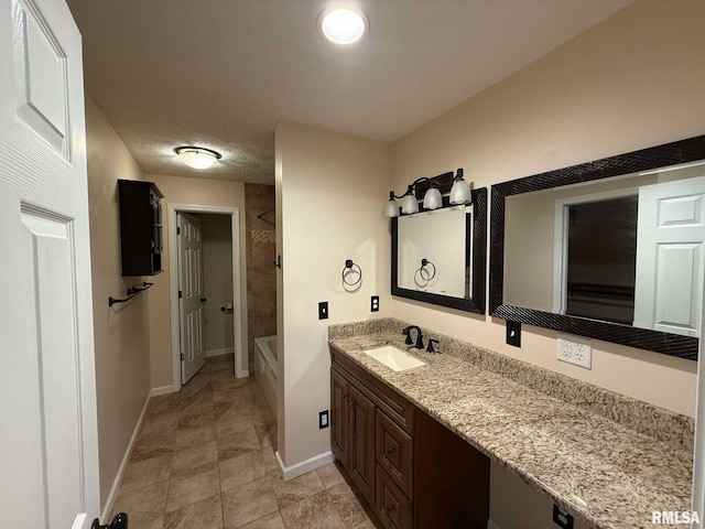 bathroom featuring tiled shower / bath and vanity