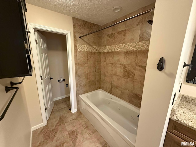 bathroom featuring tiled shower / bath combo, vanity, and a textured ceiling