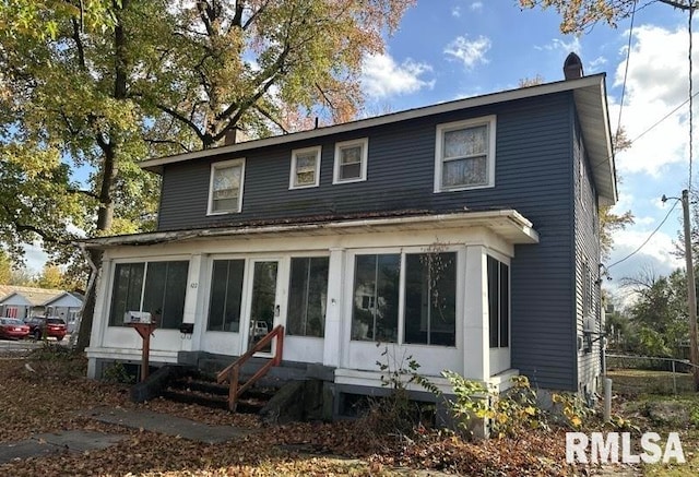 rear view of house featuring a sunroom