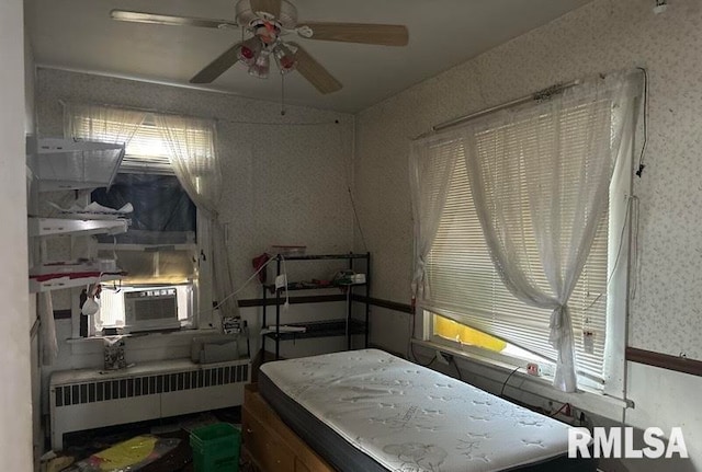 bedroom with radiator, multiple windows, and ceiling fan