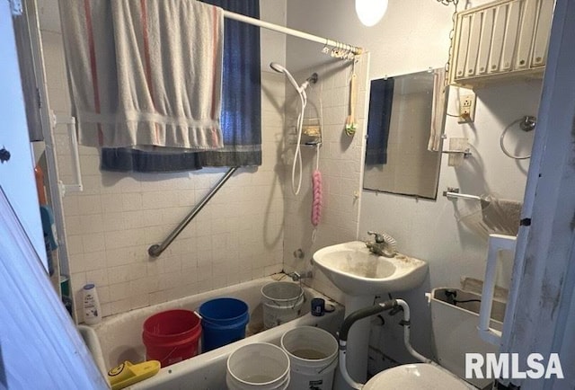 bathroom with tiled shower / bath combo and sink