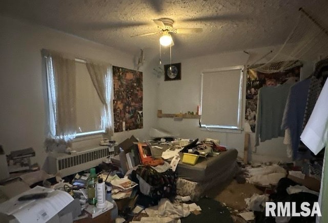 miscellaneous room featuring radiator, ceiling fan, and a textured ceiling