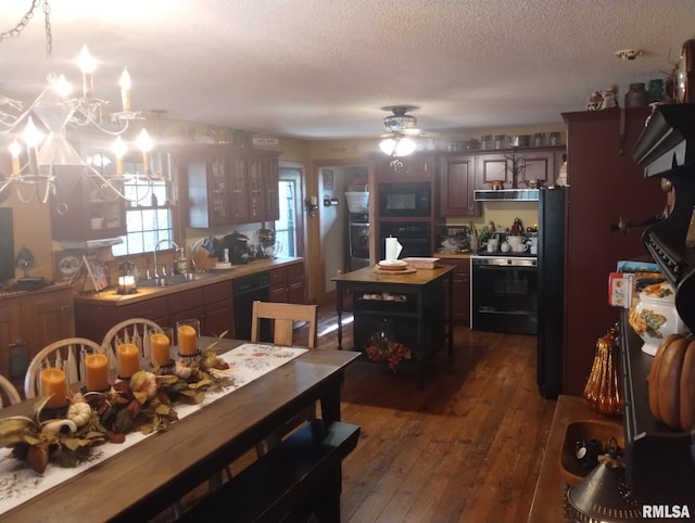 kitchen with dark brown cabinetry, sink, dark hardwood / wood-style flooring, a kitchen island, and black appliances