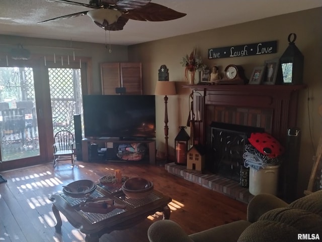 living room featuring a fireplace, hardwood / wood-style floors, and ceiling fan