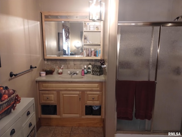 bathroom featuring decorative backsplash, vanity, a shower with door, a notable chandelier, and tile patterned flooring