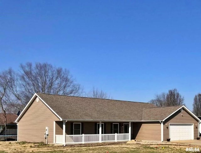 single story home featuring a trampoline, a front lawn, a porch, and a garage