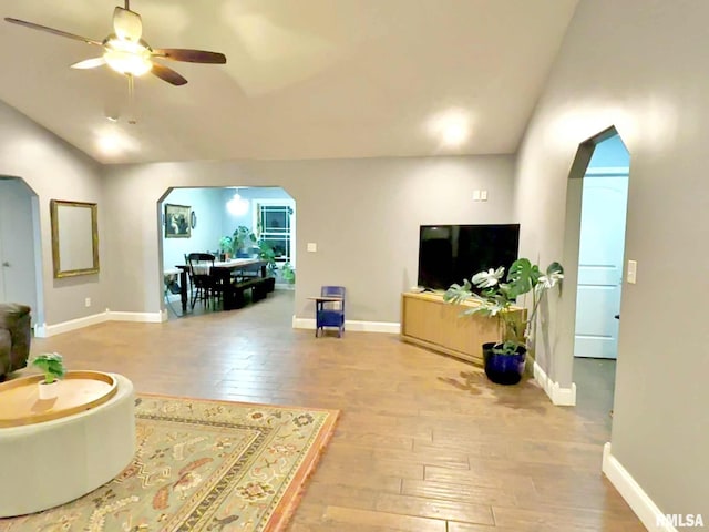 living room featuring light wood-type flooring, ceiling fan, and lofted ceiling